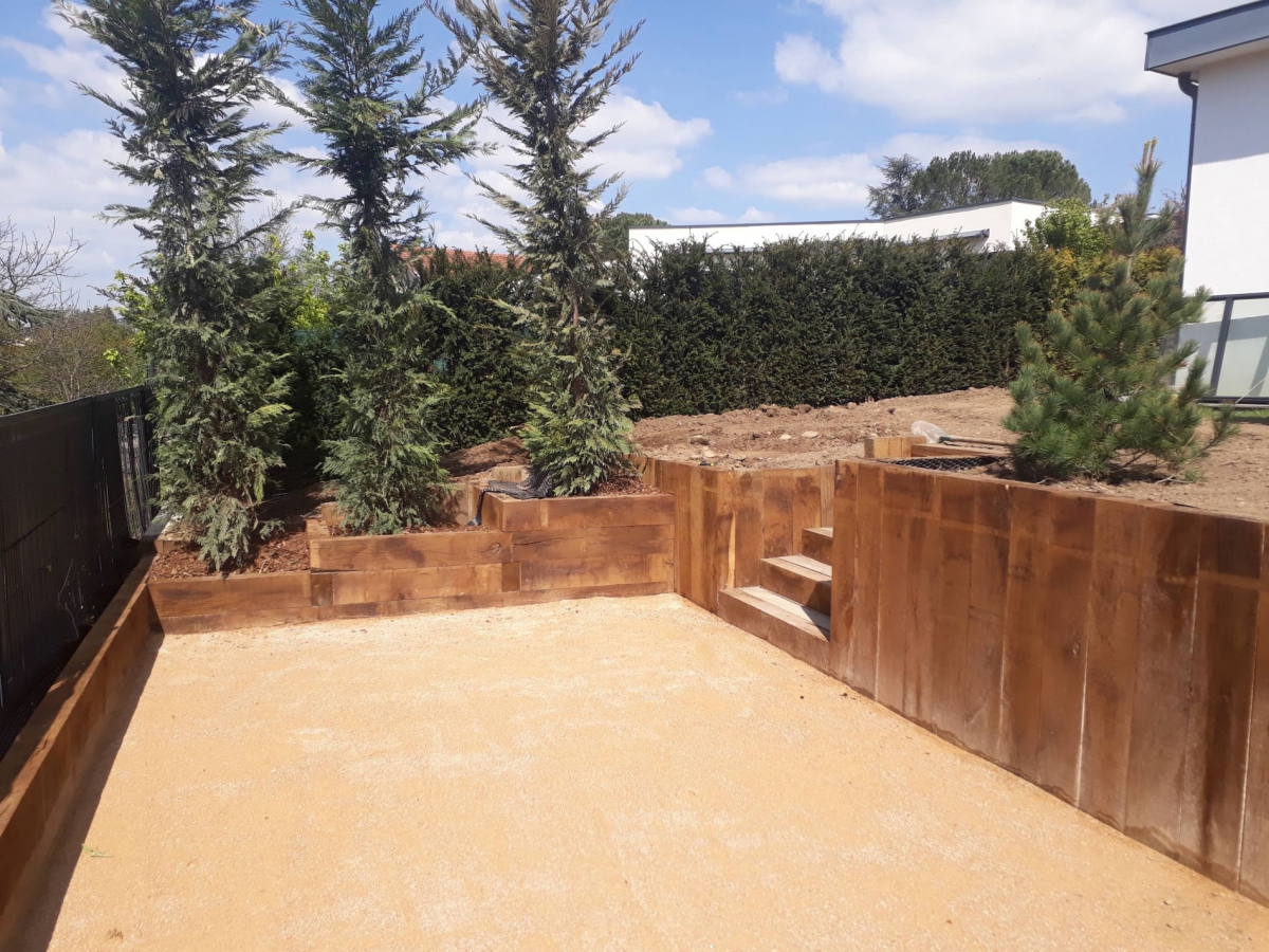 Terrain de pétanque ocre et soutènement en chêne