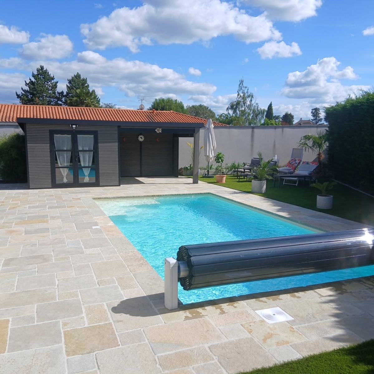 Superbe terrasse de piscine en pierre naturelle et en gazon