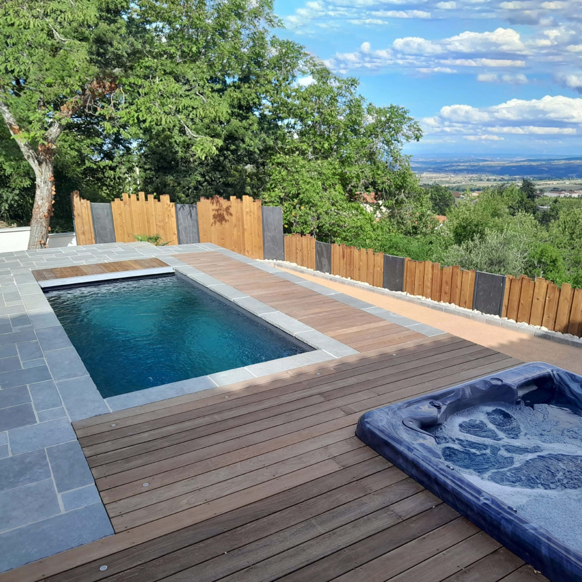 Plage de piscine mélange bois et pierres naturelles grises